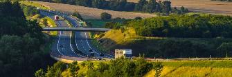 
Autobahn in grüner Landschaft im Abendlicht