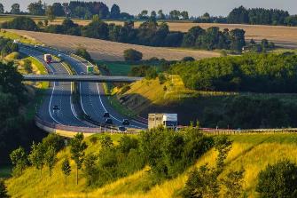 
Autobahn in grüner Landschaft im Abendlicht