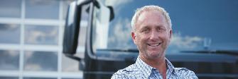 
A driver standing in front of his truck