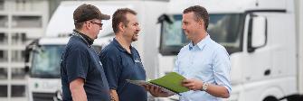 
A haulier talks to two truck drivers