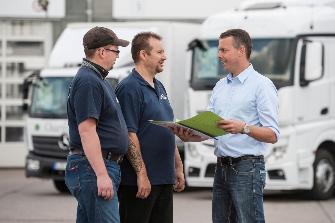 
Transporteur discutant avec deux conducteurs de poids lourds