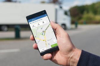 
Una mano sujeta un smartphone, la pantalla muestra la aplicación de Toll Collect.