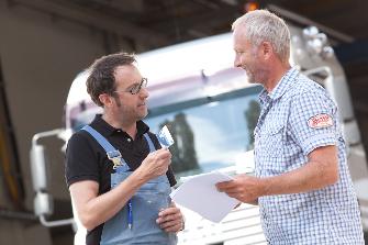 
Un partenaire de service conseille un conducteur de poids lourd sur l’appareil embarqué